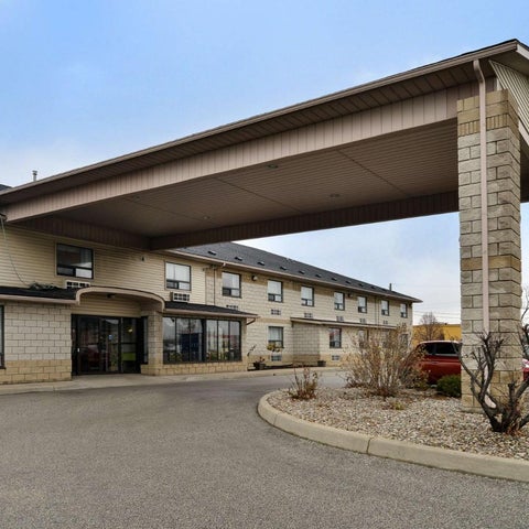 A two-story brick hotel with a covered entryway and signage displaying 'Lexington Inn & Suites' and 'Great Rates' is shown.