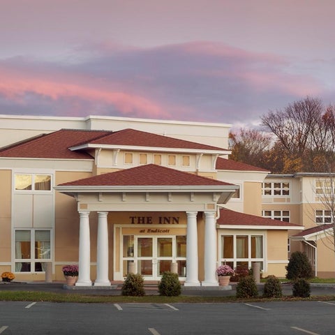 The Inn at Harbor Hill shows a large, beige building with a red tiled roof and a portico with white columns.