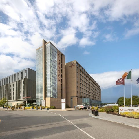 The Clayton Hotel is shown from the front with flags and a road leading to the entrance.