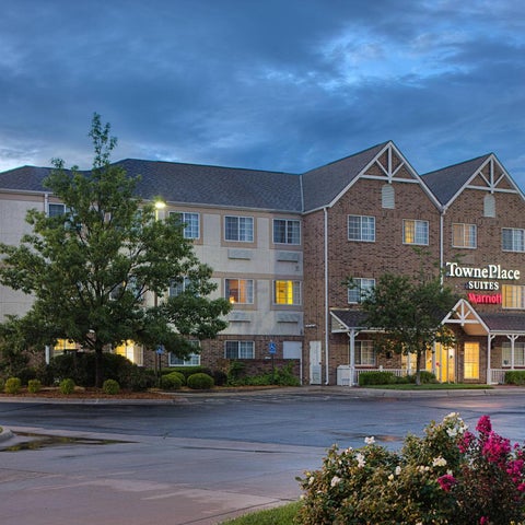 A TownePlace Suites by Marriott hotel building facade is shown with a tree and landscaping in front of it.