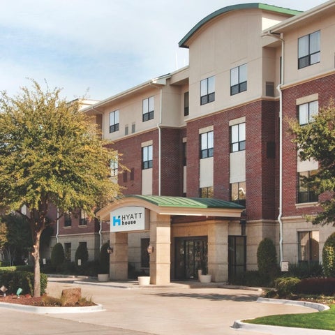 A Hyatt House hotel features a brick and stucco facade with a covered entrance and landscaped grounds.