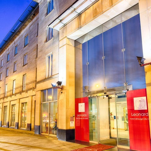 A modern hotel facade with large glass windows and a red sign displaying the name 'Leonardo Hotel Edinburgh City Centre'.