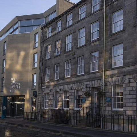 The exterior of Ten Hill Place Hotel shows a mix of modern and traditional architecture with a street-level entrance and windows.
